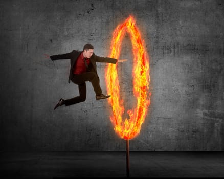 Asian business person jumping through ring of fire. Business risk conceptual