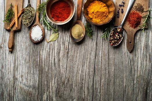 Fresh herbs and spices on a wooden background