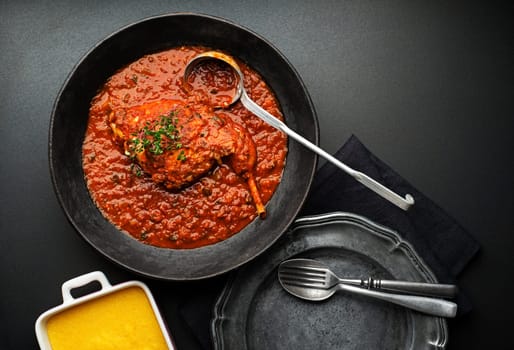 Meat stew with vegetable and tomato sauce on black background