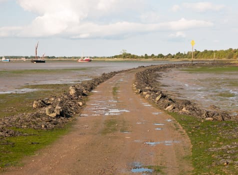 road leading onto island with tide out black water Maldon Essex  England  UK