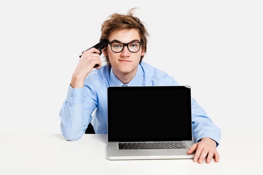 Handsome young man at home sitting on the couch and working on the laptop