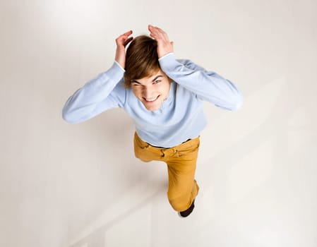Portrait of a handsome young man looking up and laughing