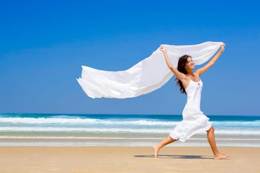 Beautiful girl running in the beach with red ballons in her hand