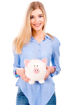 Beautiful and attractive blonde woman holding and showing a piggy bank, isolated over white background