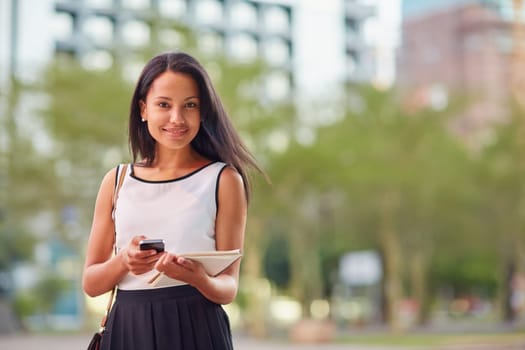 A young businesswoman working on her tablet outdoors