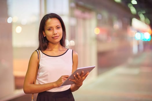 A young businesswoman working on her tablet outdoors