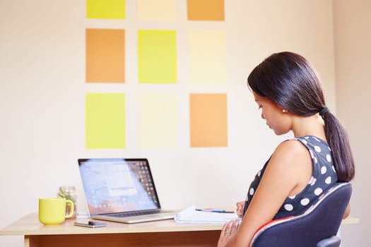 A young woman working on her laptop in her office