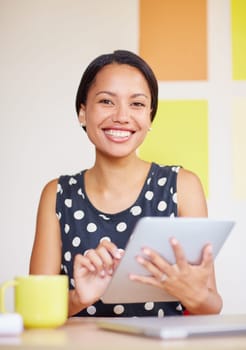 A young woman working on her digital tablet in her office