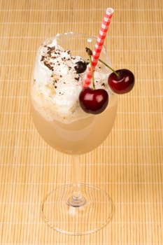 Ice coffee with whipped cream, straw and sour cherry.