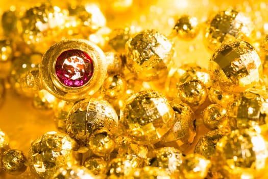 Luxury golden jewelry, pearls and ring with gem on yellow background.