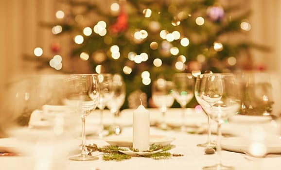 Closeup of a christmas candle on a festive table with bokeh in the background