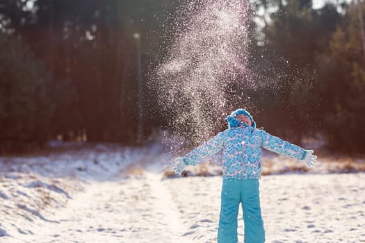 Shot of a little girl throwing a handful of snow up into the air on a sunny winter's day outdoors