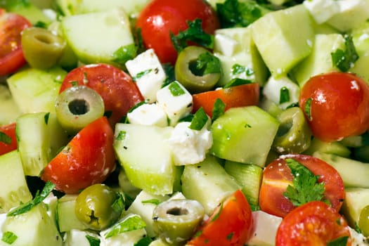 Fresh Greek salad with tomato, cucumber, olives, feta cheese and parsley.