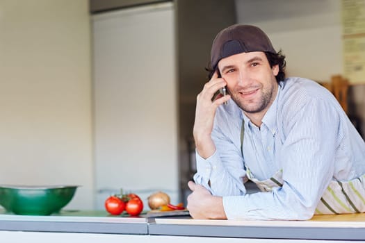 Entrepeneur smiling while making a call on his phone from his takeaway food business.
