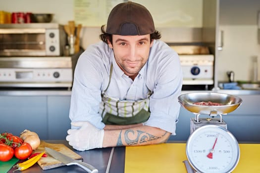Food entrepeneur looking pleased with his fresh top-quality minced hamburger meat that he weighing in a retro kitchen scale