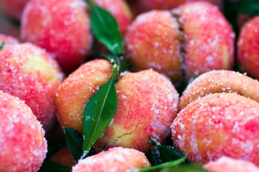 Peaches as serbian traditional dessert with sugar and green leaves.