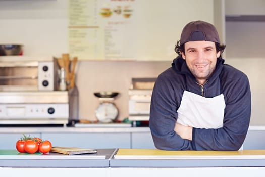 Entrepeneur looking friendly and confident in his clean food stall where he makes takeaway food