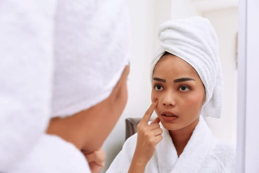 Young asian woman with bath towels cleanses her face at the bathroom