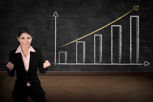 Business person smile over increasing graph drawing on chalk board