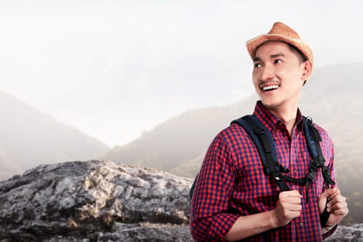 Young asian traveler smiling when hiking on the mountain