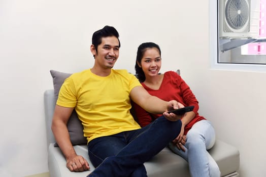 Portrait of asian couple enjoying watching television together at home