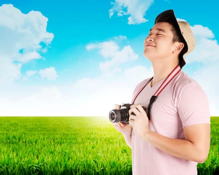Asian tourist take photo on green meadow. Summer holiday concept