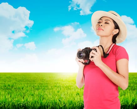 Young woman tourist, photograph landscape of green meadow