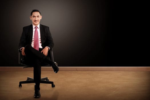 Business man sitting on the chair with black background