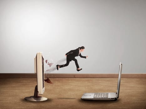 Business woman jumping from desktop computer to laptop. Switch to mobile technology
