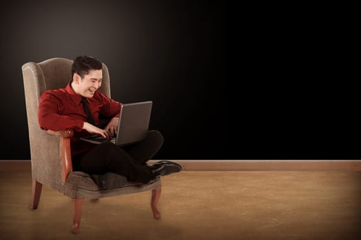 Young asian business man working with laptop and sitting on the chair