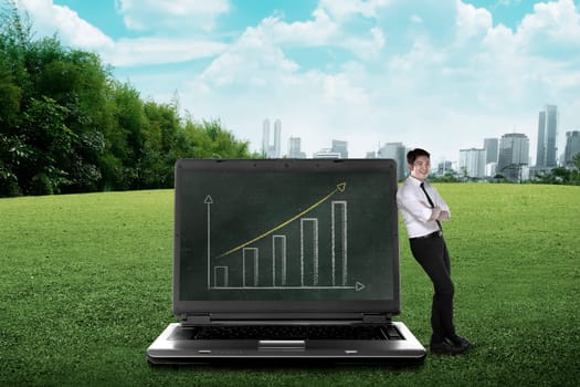Asian business man leaning on big laptop, show report