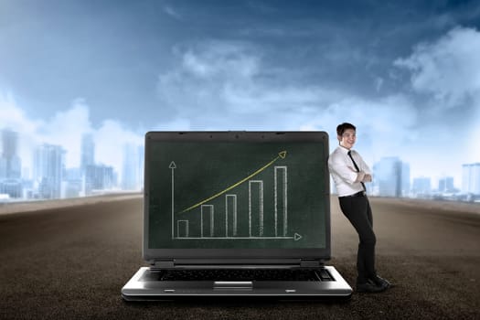 Asian business man leaning on big laptop, show report