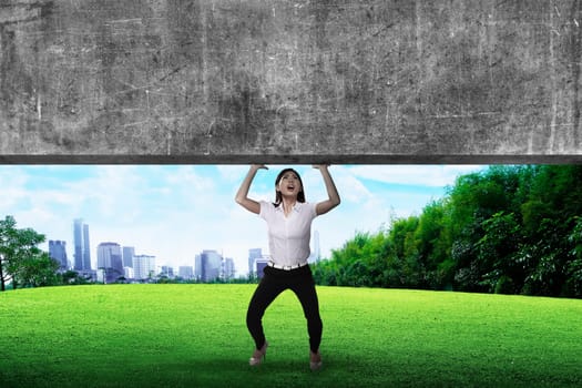 Asian business woman lift heavy block. Business challenge concept