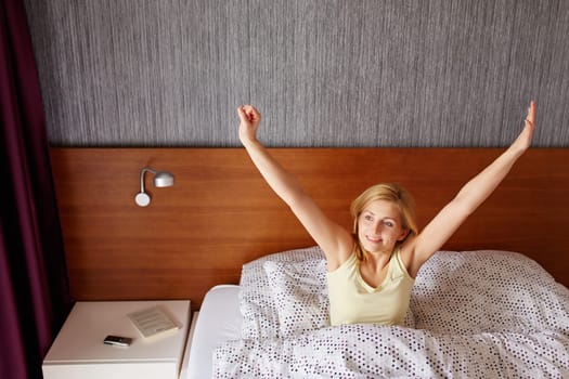 A young woman stretching out after waking