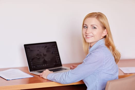 A young businesswoman working on her laptop in her office