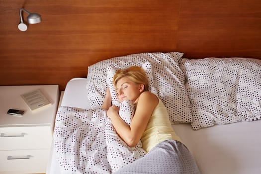 A young woman asleep in her bed