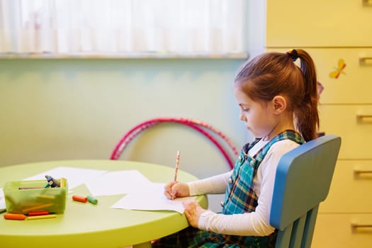 A little girl drawing in her room