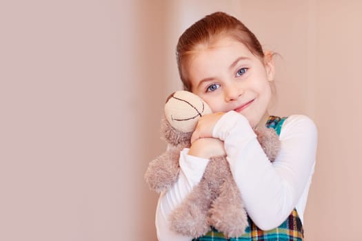 A cute little girl holding her teddy bear
