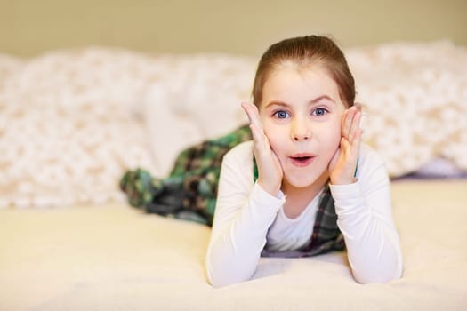 A cute little girl lying on the floor while pulling a face