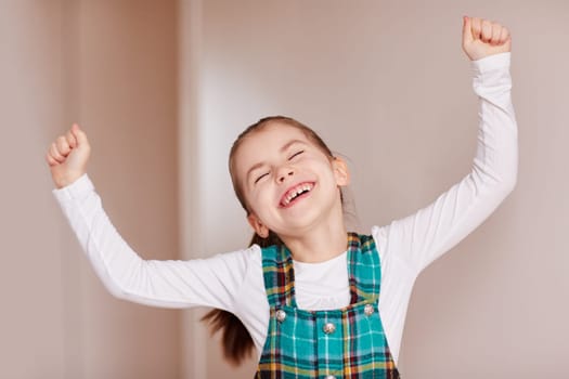 A cute little girl throwing her hands in the air.