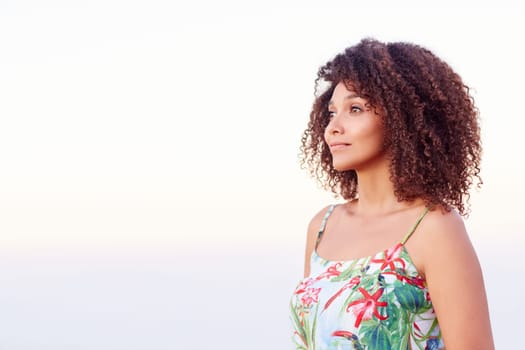 Confident mixed race woman with a serene expression looking away while standing outdoors