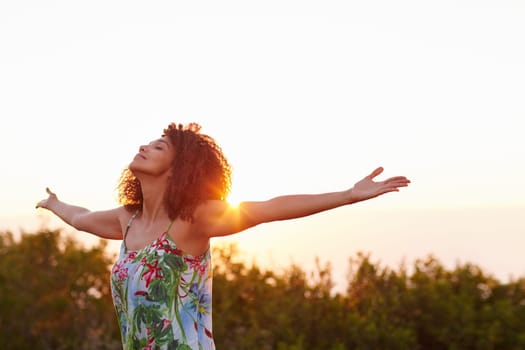 Beautiful mixed race woman expressing freedom outdoors with her arms outstretched