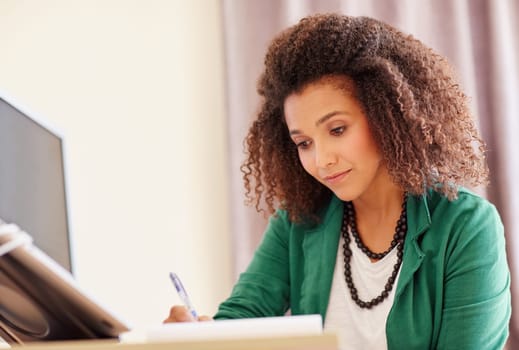 Young woman with an afro hairstyle, working at her office desk