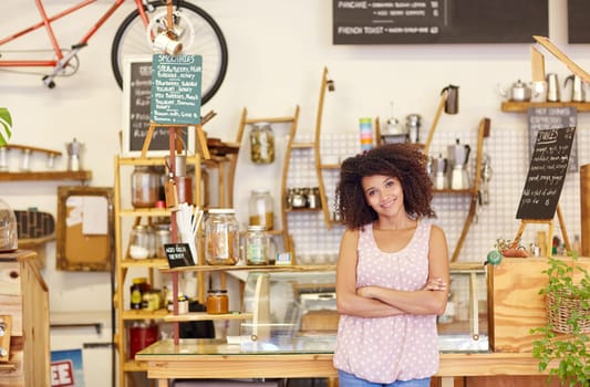 Young woman standing confidently in her coffee shop, proud of being a small business owner