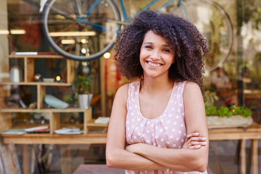 Beautiful mixed race woman standing confidently outside the front of her coffee shop