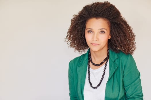 Beautiful young mixed race businesswoman looking at the camera confidently wearing a green jacket