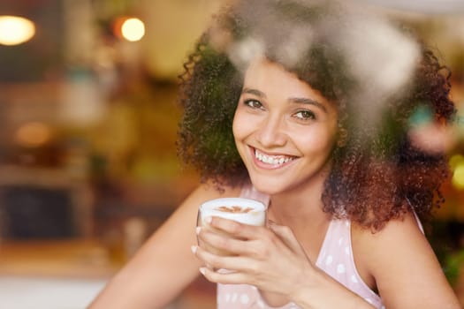A beautiful young woman seen through the window of a coffee shop