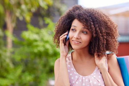 Beautiful woman talking on her phone while out on a shopping spree