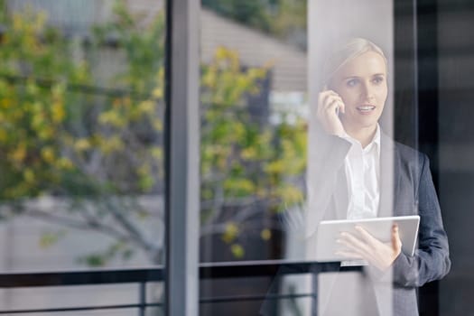 A young businesswoman seen working through her office window