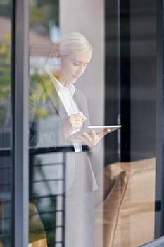 A young businesswoman seen working through her office window
